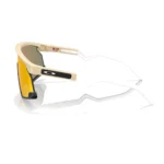 Oakley BXTR OO9280-0439 con montura beige mate y lentes Prizm Ruby, vista lateral sobre fondo blanco.