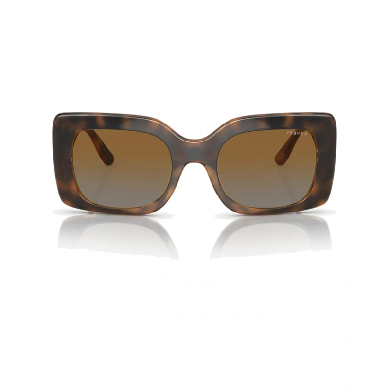 Vogue VO5481S 299013 con montura caramelo transparente y lentes marrón degradado, vista frontal sobre fondo blanco.